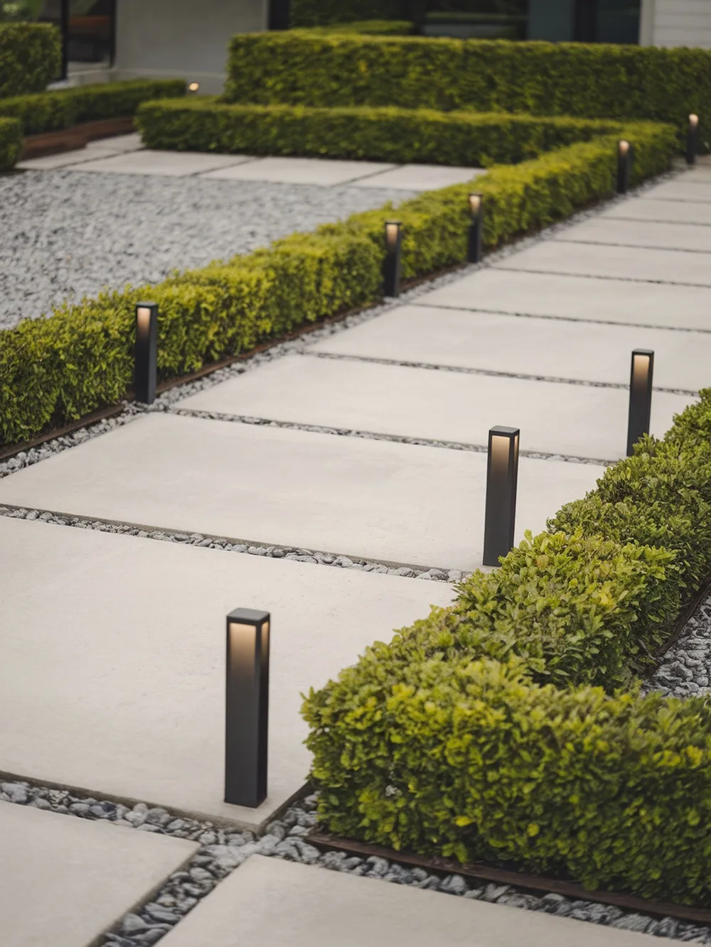 Pathway illuminated by modern bollard lights in a garden setting.