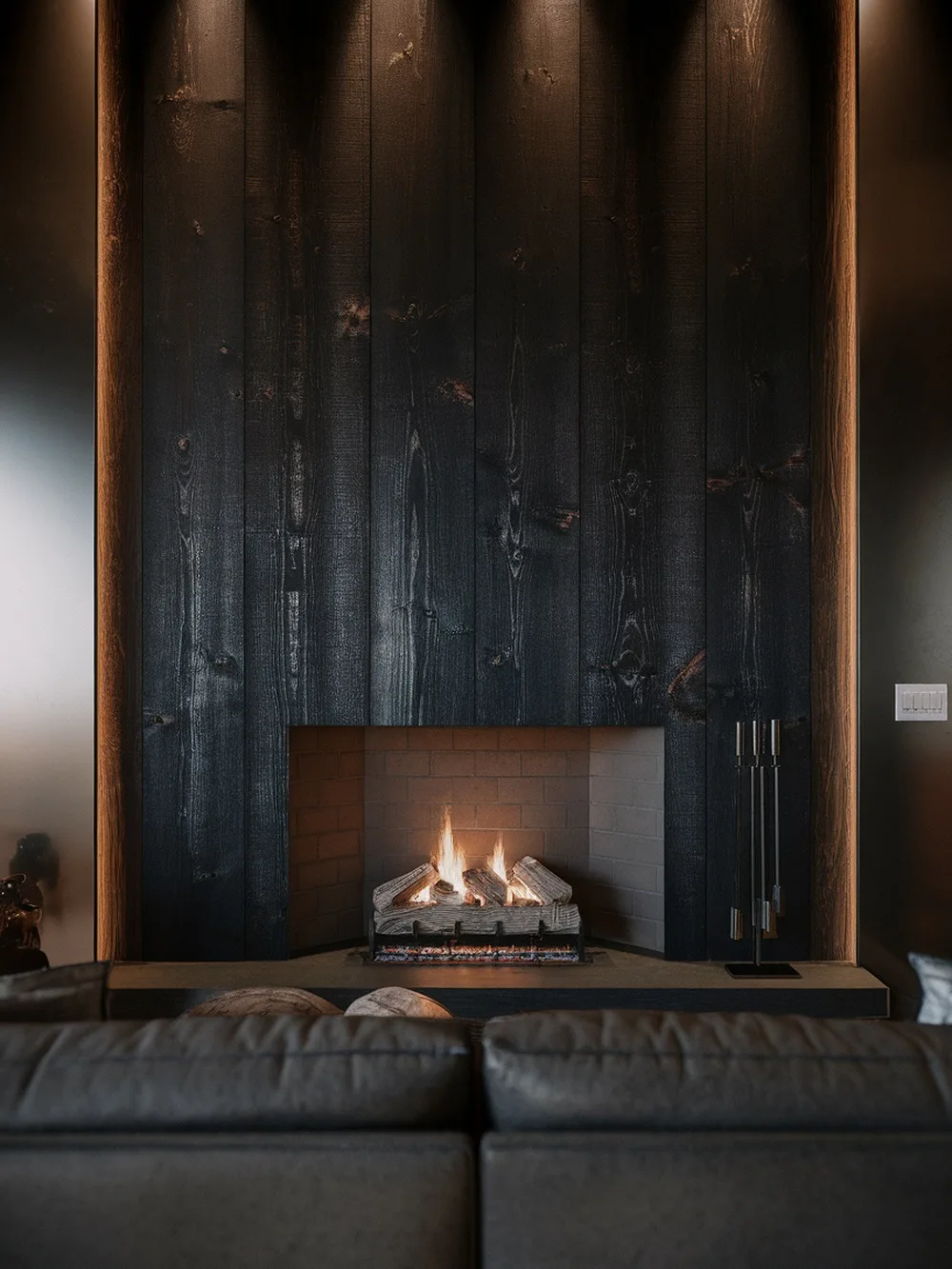 A modern fireplace with a charred wood accent wall, featuring a sleek design and warm flames.