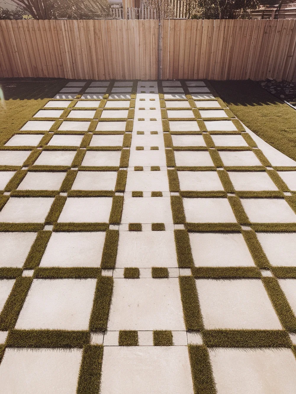 Checkerboard paver walkway with grass in between