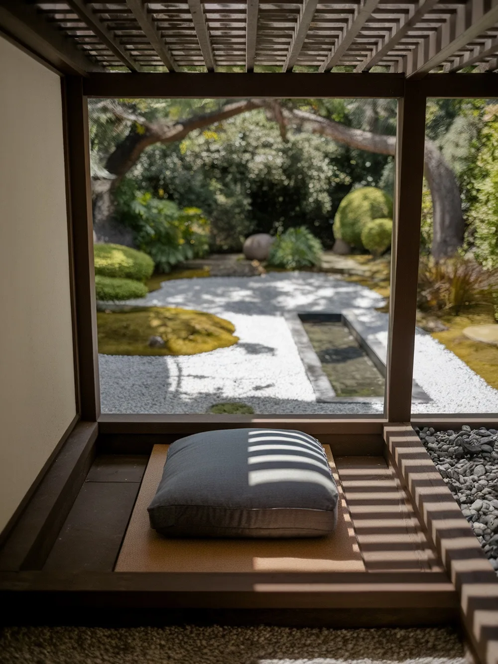 A peaceful garden nook with a cushion overlooking a serene Japanese garden.